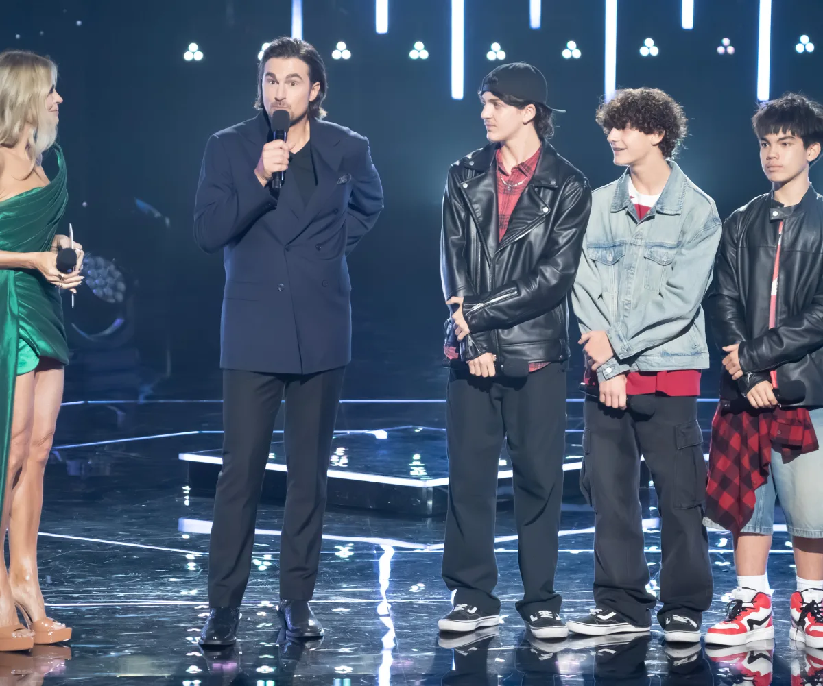 Tommy stands on stage next to young band Wave Raiders