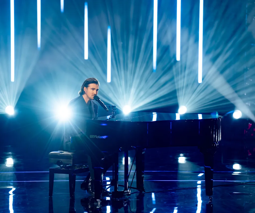 Tommy plays the piano on the set of The Voice
