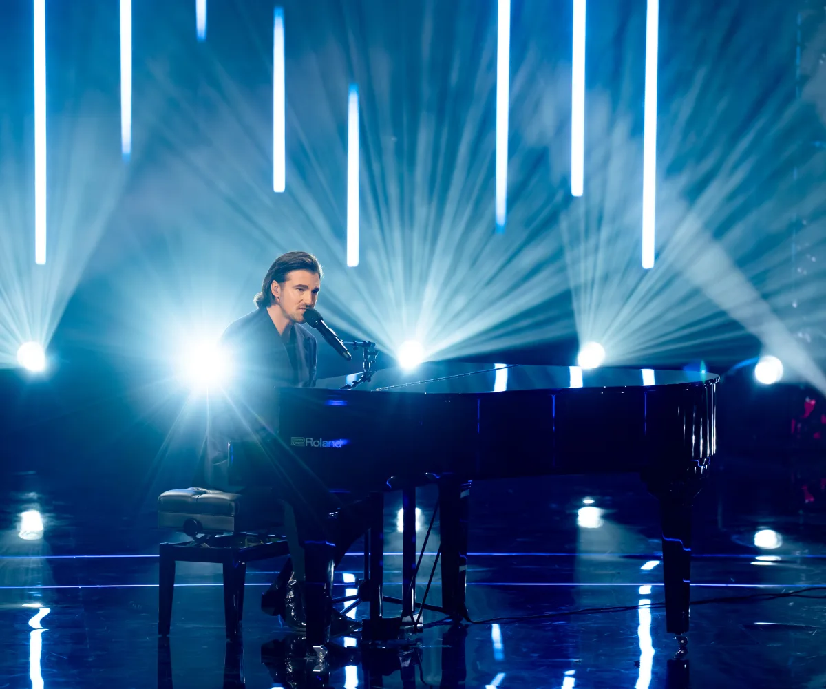 Tommy plays the piano on the set of The Voice