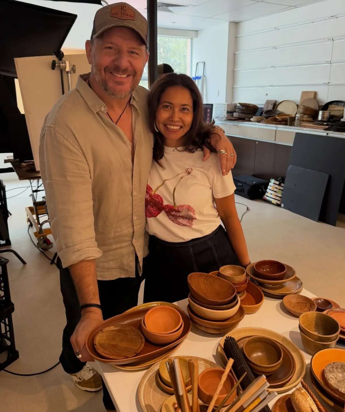 Manu stands with his arm around Clarissa in a kitchen