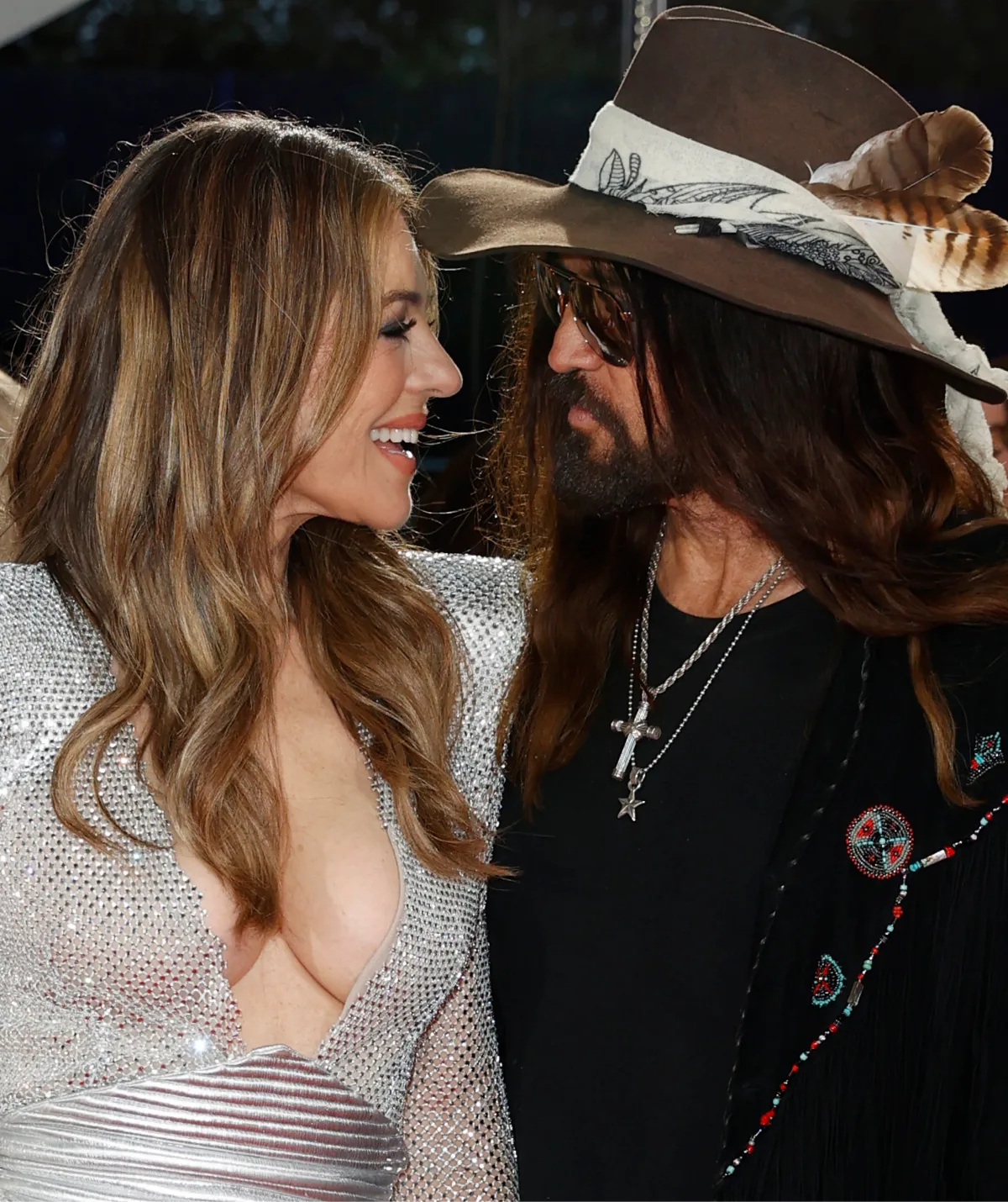 Liz Hurley and Billy Ray Cyrus look into each other's eyes and smile