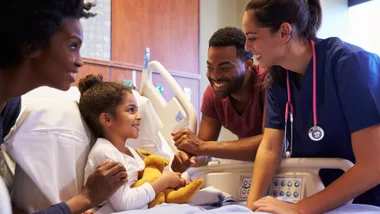 Family in hospital with sick daughter speaking to doctor