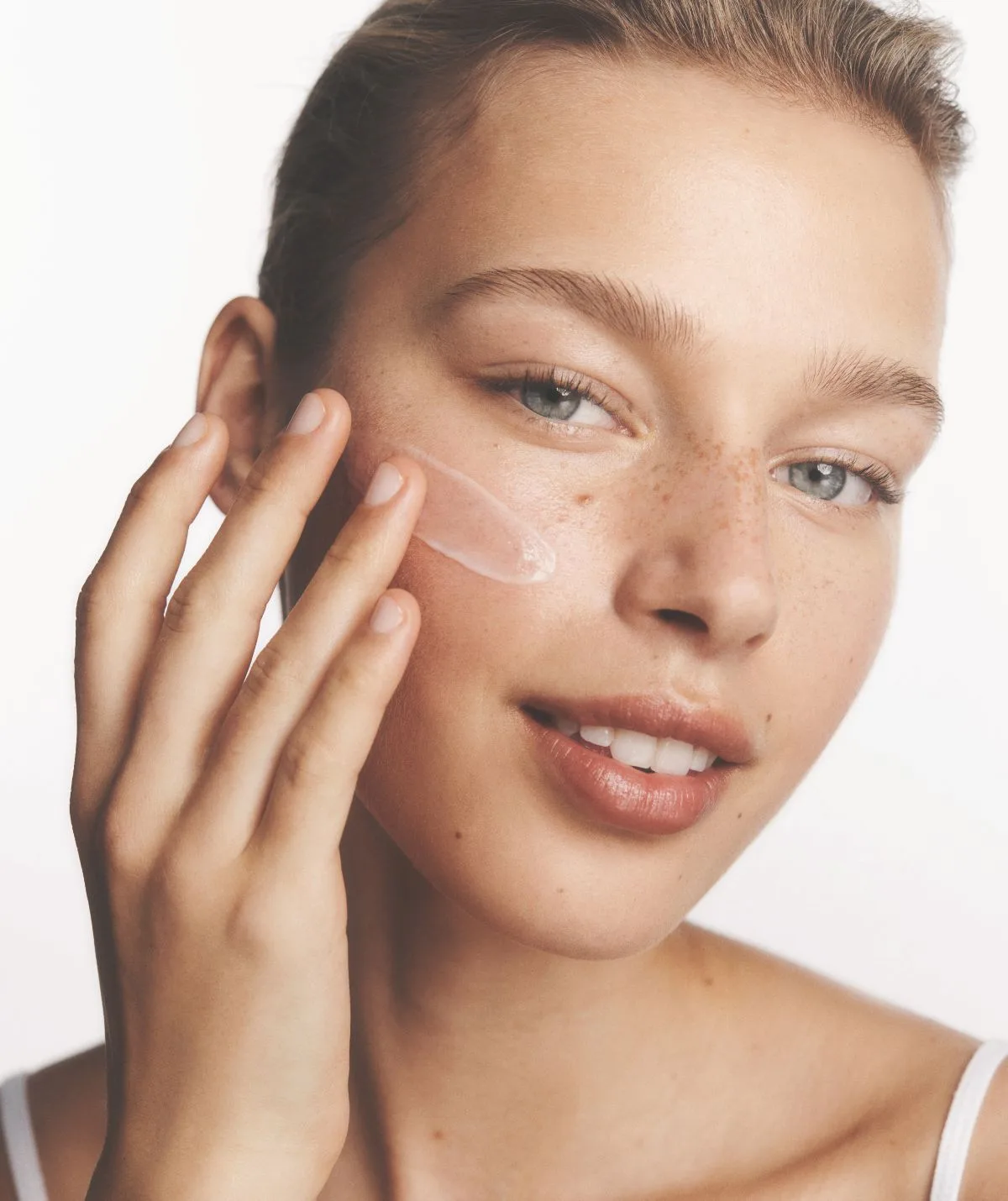 Woman applying moisturiser to face