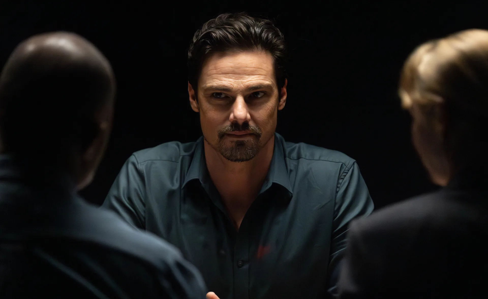 Jay Ryan, as Simon, stares straight ahead in a police interview room on Dustfall