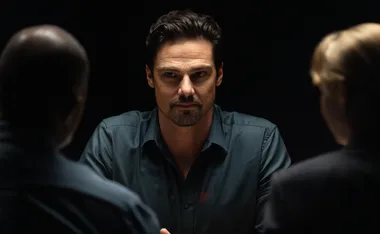 Jay Ryan, as Simon, stares straight ahead in a police interview room on Dustfall