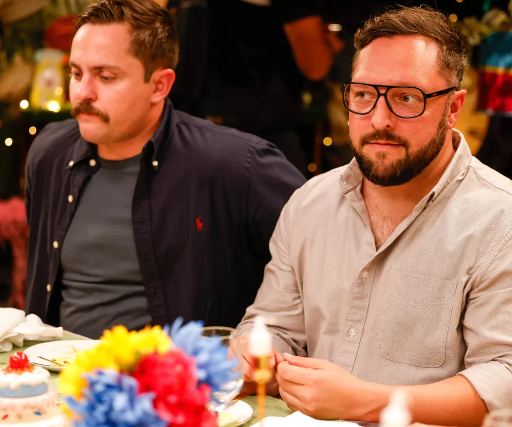 Angus and Simon sit next to each other at the dinner table