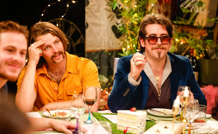 Harrison and Oliver sit next to each other at the dinner table