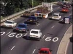 Highway with several cars, trucks, and visible speed limit signs showing 60.