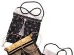 Elegant evening bags, featuring black and gold patterns, tassels, and a mix of delicate materials, arranged stylishly.