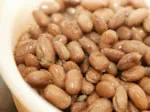 Bowl of cooked pinto beans, a protein-rich food option.