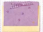 Purple baby card with a checkered bow and safety pins, layered on a yellow background.