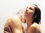 A couple intimately embracing in a shower, water cascading over them, conveying a sense of sensuality and closeness.