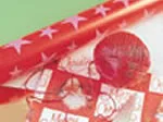 Red and white star-patterned wrapping paper with a red ribbon and ball.