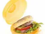 Yellow lunchbox with sandwich, featuring lettuce, tomato, cucumber, and red onion.