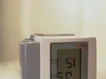 Digital blood pressure monitor displaying a reading on a light-colored surface.