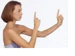Woman practicing finger focus exercise for eye strain relief, extending index fingers at different distances.