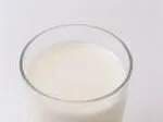 A glass filled with milk on a white background.