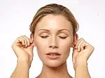 A woman with eyes closed, massaging her ears for relaxation and instant energy boost.
