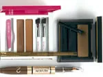 Eyebrow grooming kit with pencil, brushes, tweezers, and powders for shaping and defining eyebrows.