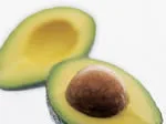 Two avocado halves, one with a pit, on a plain background.