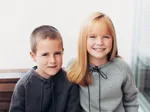 Boy and girl smiling, wearing Fred Bare sweaters.