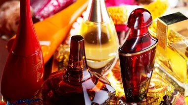 Array of exotic perfume bottles including Samsara, displayed on an ornate surface.