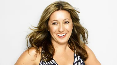 Blonde woman smiling in a striped top against a plain background.