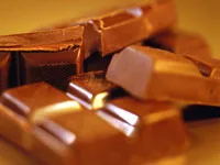 Chunks of milk chocolate stacked together on a warm-toned background.