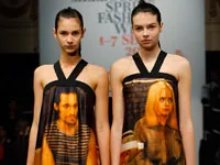 Models wearing dresses with printed faces on a Fashion Week runway, presenting unique and artistic designs.