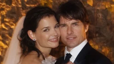 A couple in formal attire posing together at an event, smiling warmly at the camera.