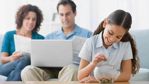 , parents with daughter, piggy bank, Getty Images