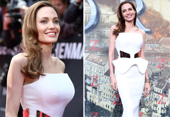 Angelina Jolie in a white strapless dress at a movie premiere event, smiling with a backdrop featuring "World War Z."