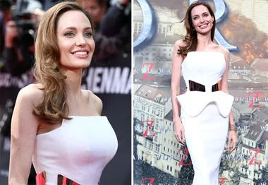 Angelina Jolie in a white strapless dress at a movie premiere event, smiling with a backdrop featuring "World War Z."