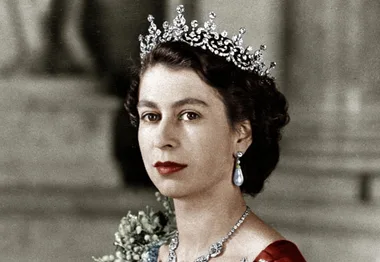 Royal portrait of a woman in a tiara and earrings, holding flowers against a blurred background.
