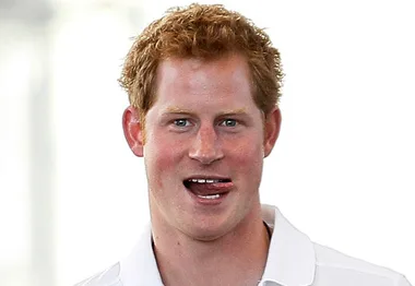 Red-haired man smiling playfully with tongue out, wearing a white shirt.