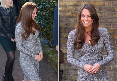 Duchess of Cambridge in a patterned dress, showing baby bump, smiling outside in London with people in the background.