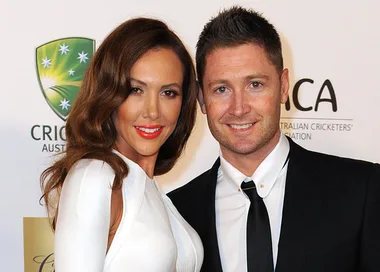 Two well-dressed individuals posing on a red carpet at the Allan Border Medal event, with the Cricket Australia logo behind.