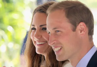 A smiling couple, with a man and woman looking forward, in a bright setting.
