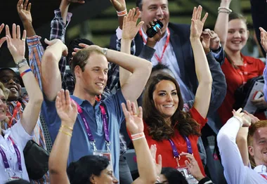 Crowd at an event with people raising their arms in celebration.