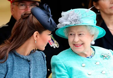 Kate Middleton and Queen Elizabeth II sharing a moment, dressed elegantly at a formal event.