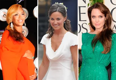 Three women in elegant dresses: one in orange, the next in white with floral hair adornment, and one in green on a red carpet.
