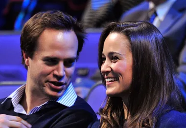 A man and woman smiling, sitting together in a theater setting.