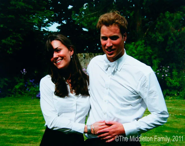 Kate Middleton and a man smiling, standing close together in a garden, both wearing white shirts.