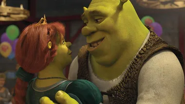 Shrek and Fiona share a tender moment at a party, surrounded by colorful balloons and festive decorations.