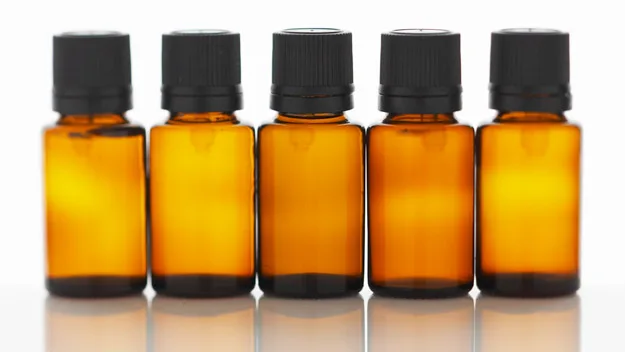 Amber essential oil bottles with black caps in a row.