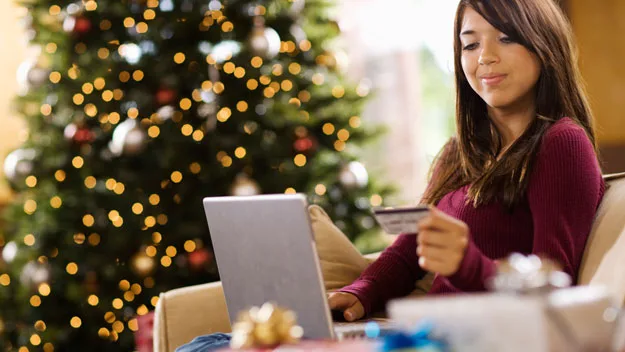 women with credit card near christmas tree, thinkstock