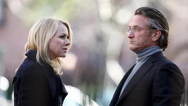A man and woman in a tense outdoor conversation, wearing formal attire, from the movie "Fair Game."