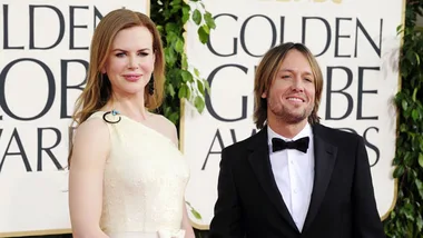 Nicole Kidman in an elegant gown with Keith Urban at the Golden Globe Awards, smiling for cameras.