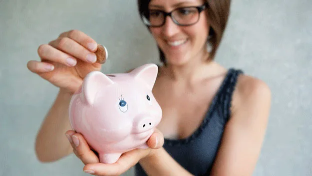 woman with piggy bank, getty