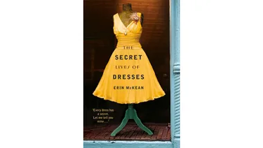 Yellow vintage dress on mannequin in shop window; book cover of "The Secret Lives of Dresses" by Erin McKean.